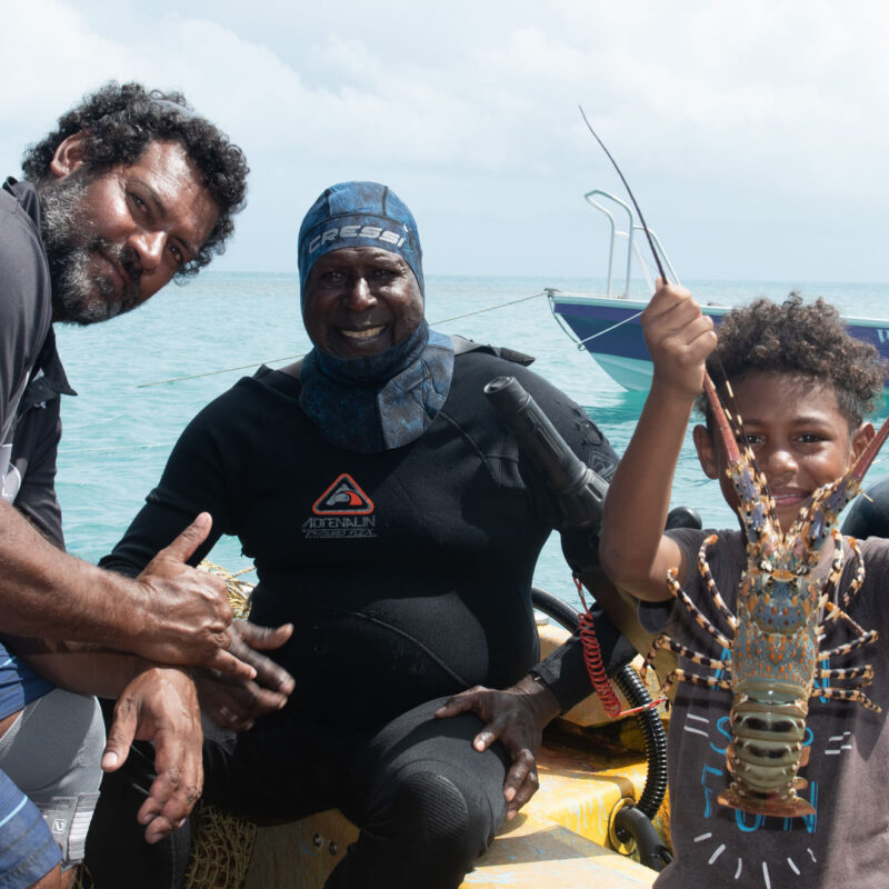 Photo of family in PNG with Lobster in hand